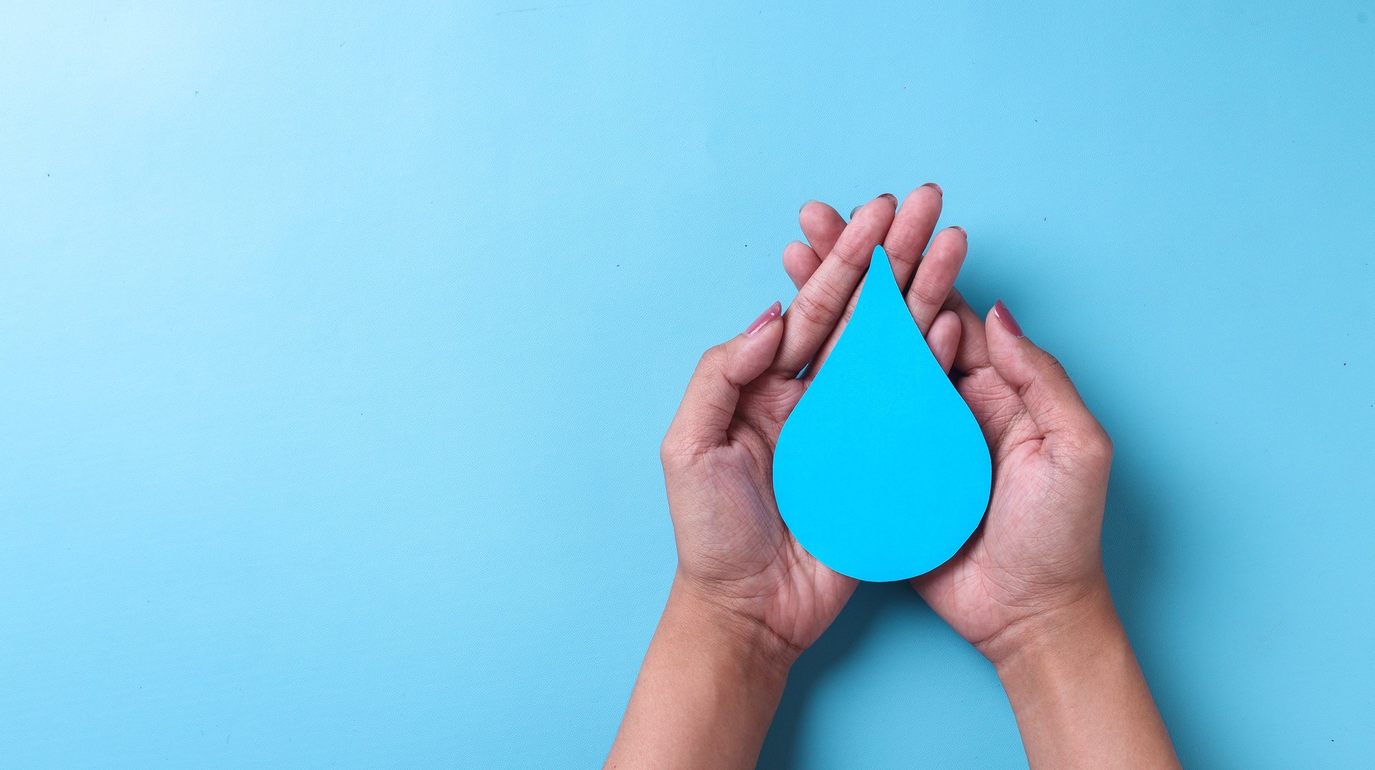 hands-holding-paper-water-drop-on-blue-background-2023-03-18-01-55-08-utc-1